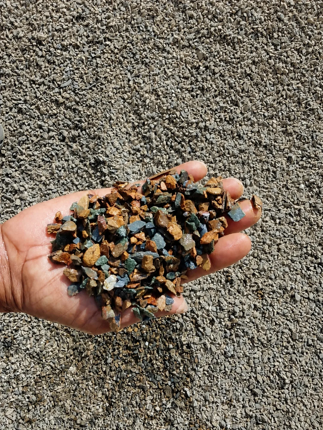 Construction aggregate sample held above the stockpile