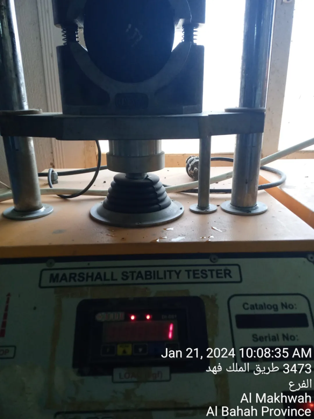 Marshall stability testing equipment operating on an asphalt specimen