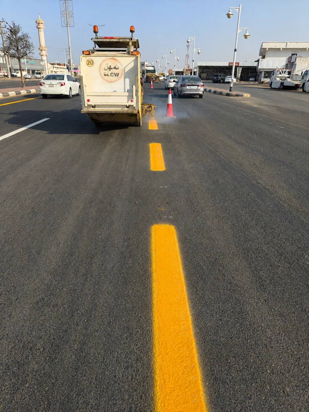 Road-marking vehicle applying a yellow pavement line